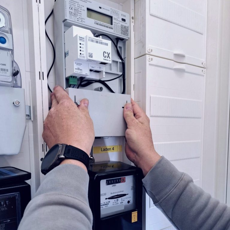 Eine Person installiert einen Energiezähler in einem Verteilerschrank. Knor Elektrotechnik, Elektriker in Hannover, Braunschweig